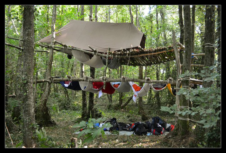 Une structure de hamacs sous une tente avec terrasse.
